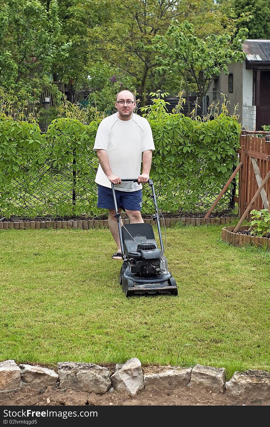 Man cutting grass at suburban house