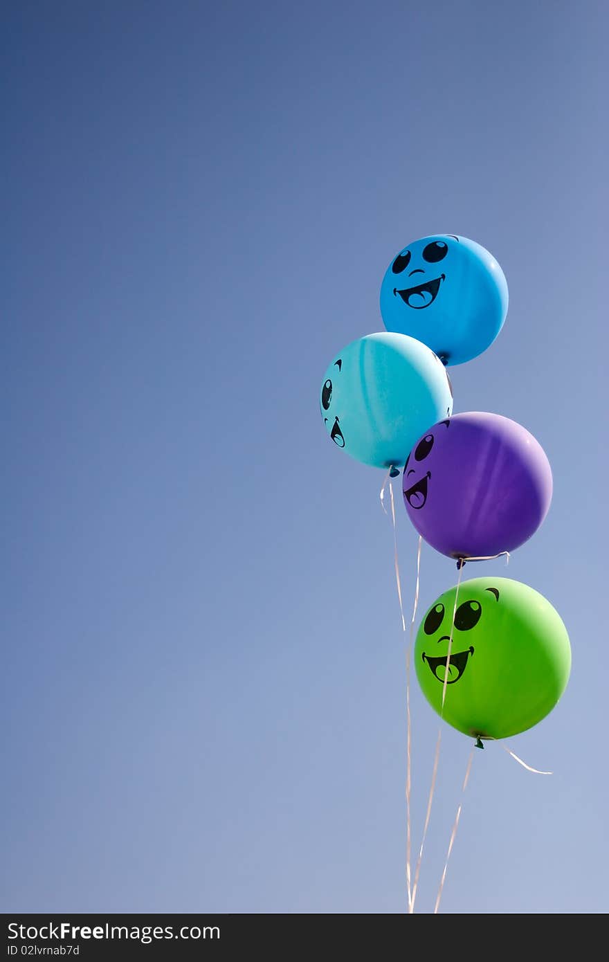 Four happy balloons with smile in cyan sky