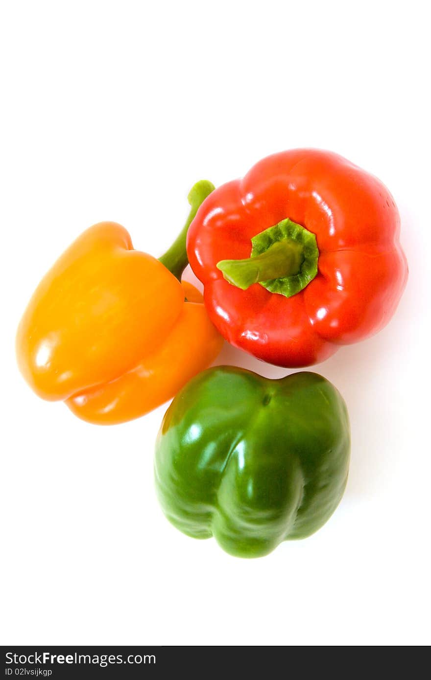 Green, orange and red bell peppers above white. Green, orange and red bell peppers above white