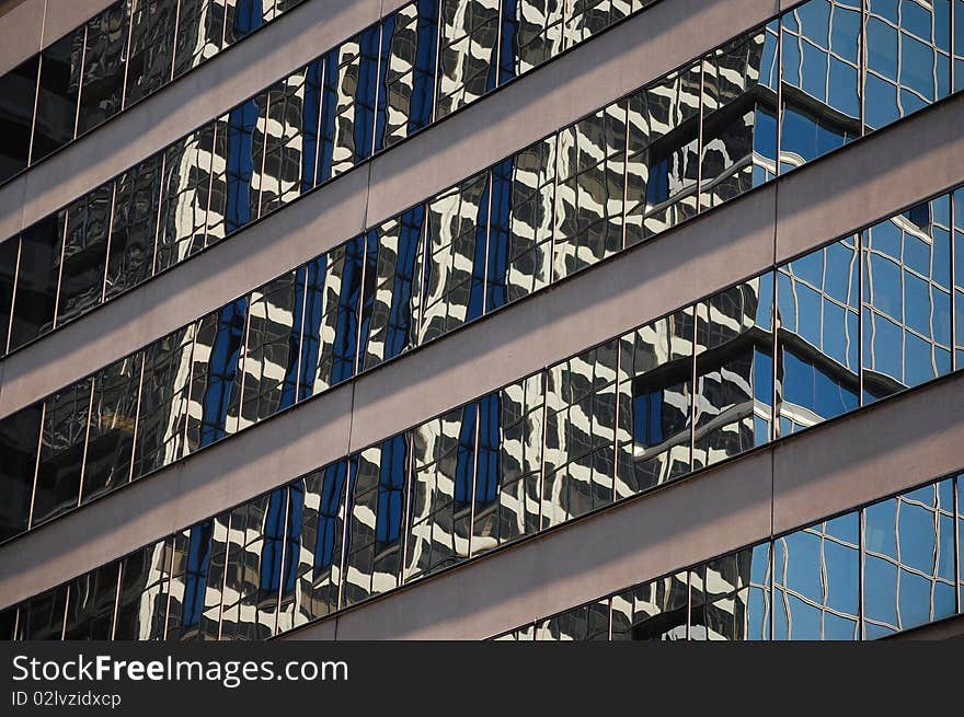 Reflections of a skyscraper in the windows of an office building. Reflections of a skyscraper in the windows of an office building