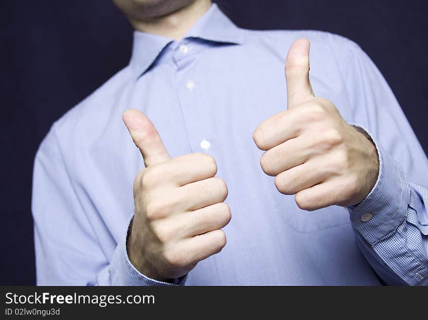 Happy young businessman in a blue shirt with a finger gesture OK. Happy young businessman in a blue shirt with a finger gesture OK