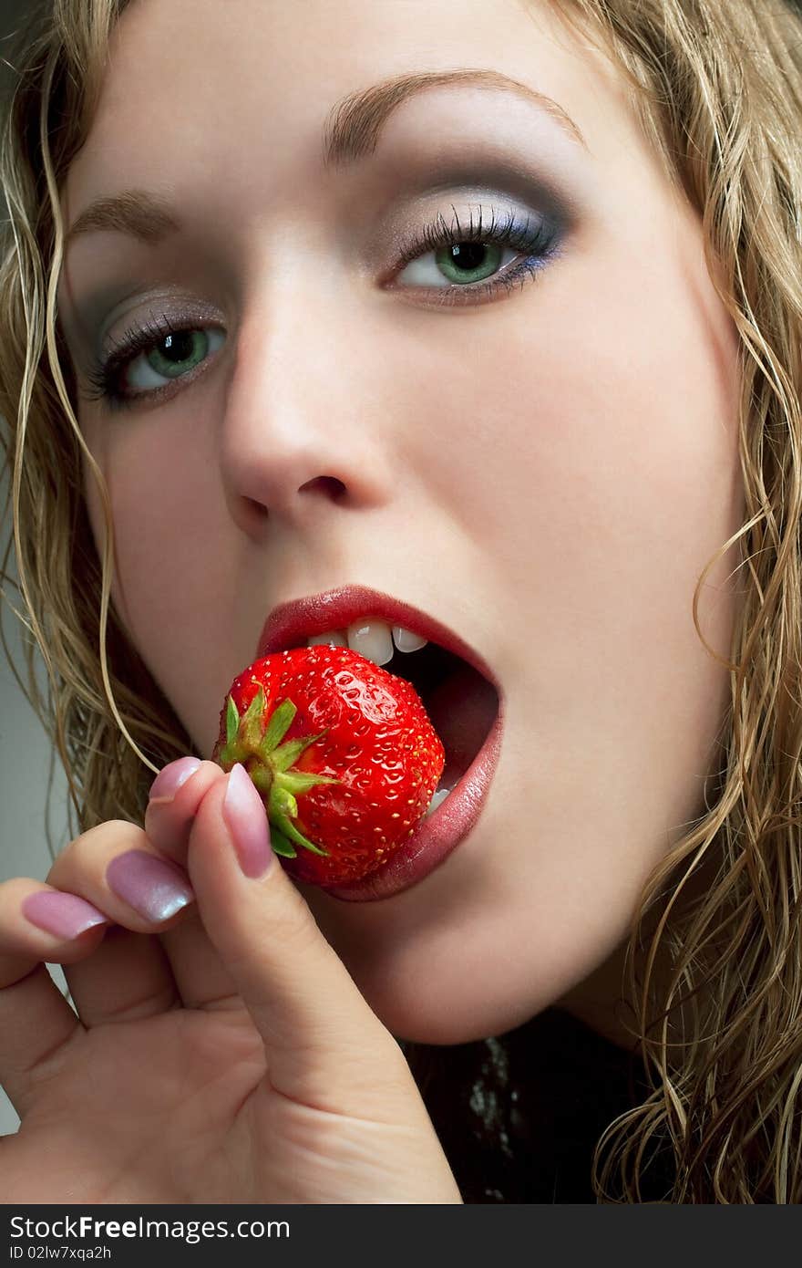 Girl bitting strawberry