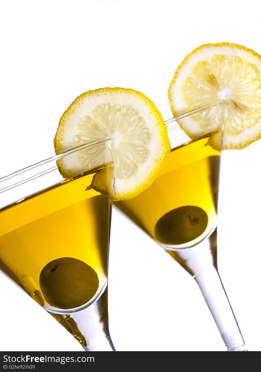 Two glasses with classical martini, garnished olive and lemon. Two glasses with classical martini, garnished olive and lemon.