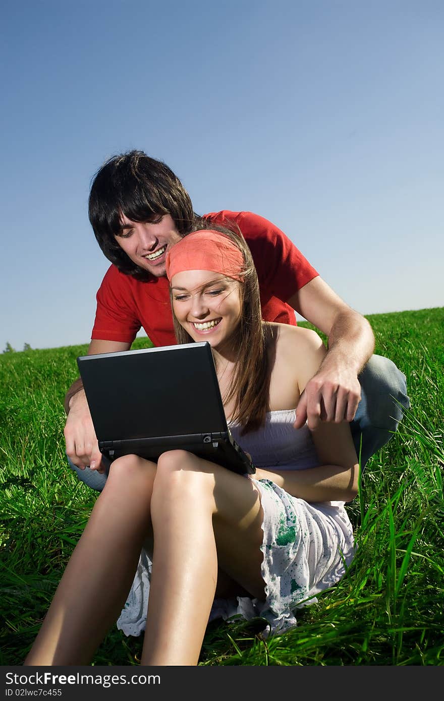 Girl with notebook and boy with smile on grass. Girl with notebook and boy with smile on grass