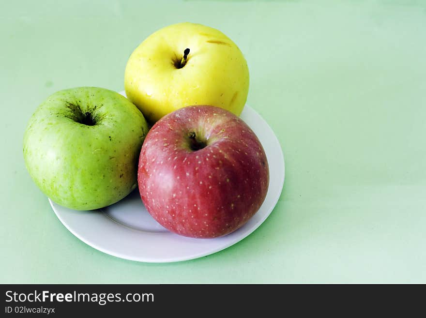 Three apples in a plate.