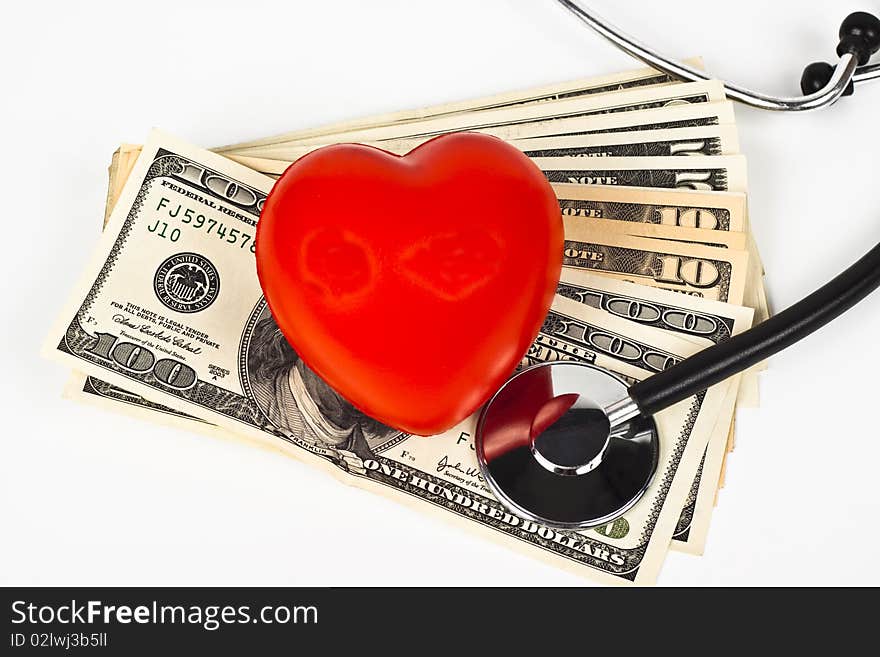 Red heart dollar bills and a stethoscope on white background. Red heart dollar bills and a stethoscope on white background