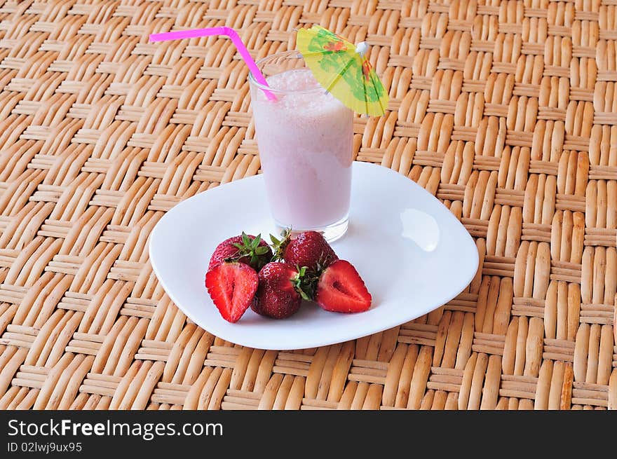 Glass of strawberry milkshake on the table