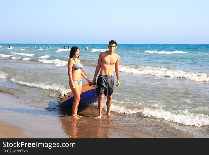 Couple with boat walking at  the sea.