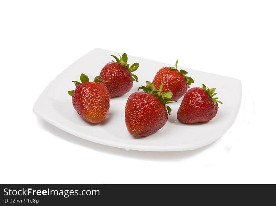 Ripe strawberry on a white plate on a white background