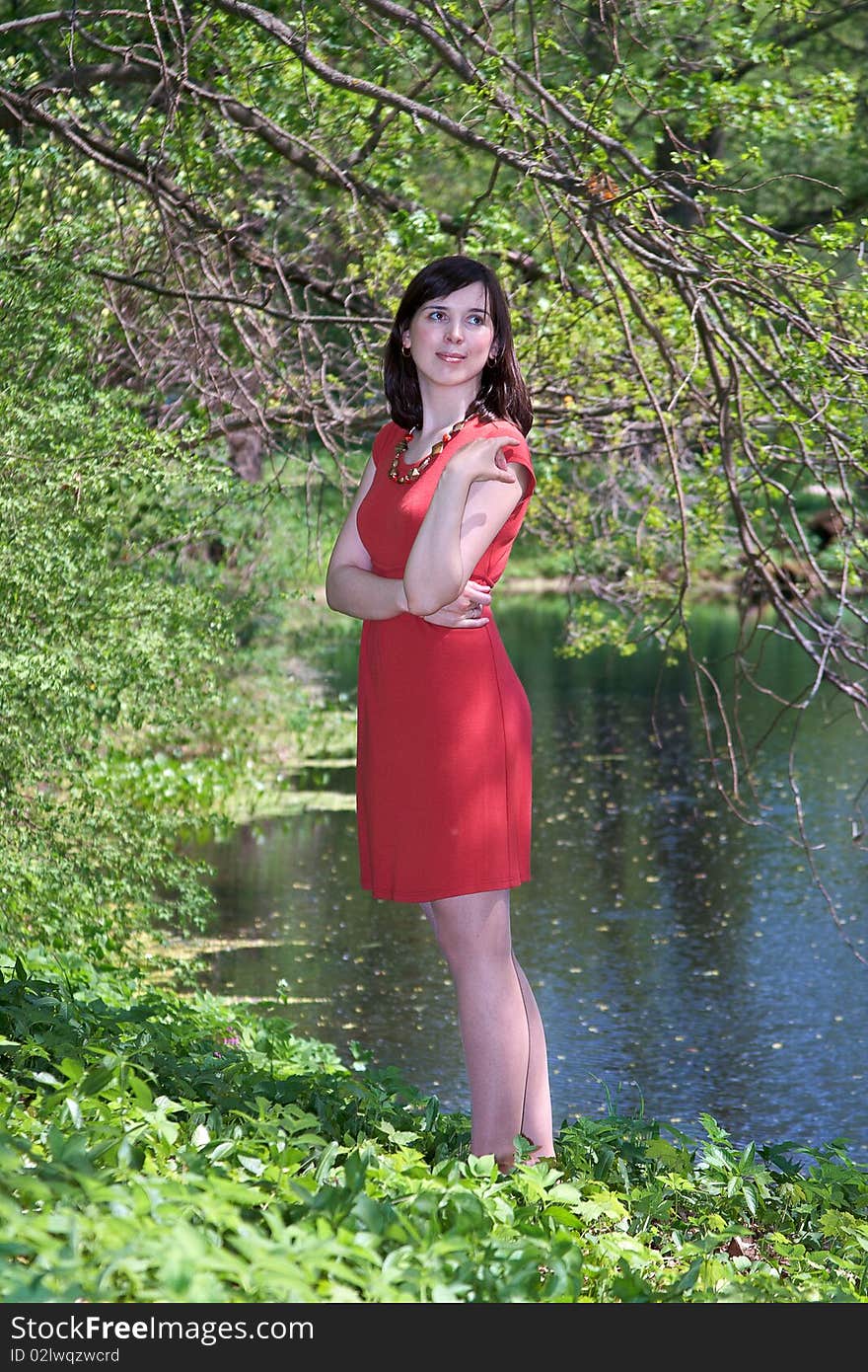 Girl in red dress smiling in a forest. Girl in red dress smiling in a forest