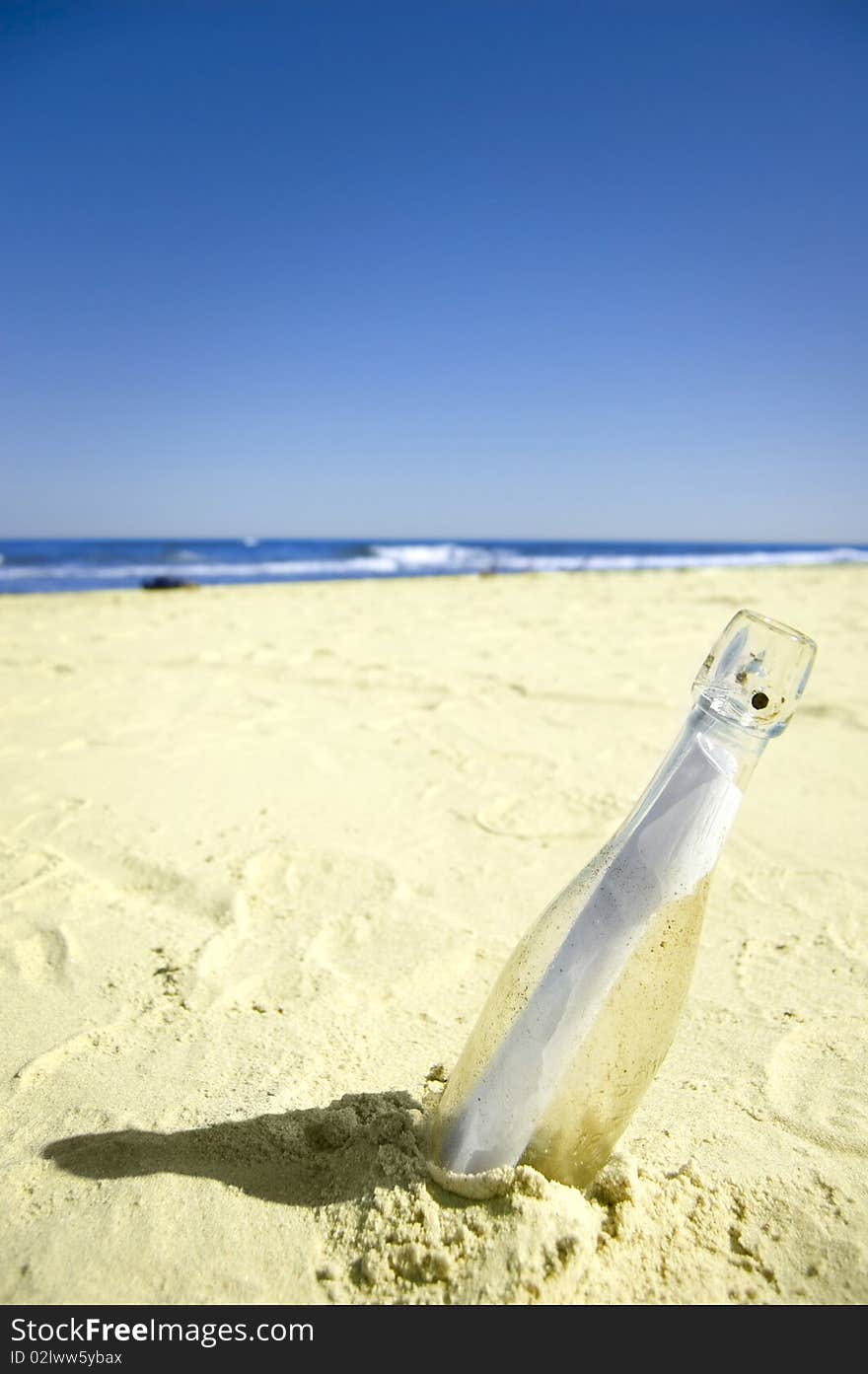 Message conceptual image. Message in a bottle on sand.