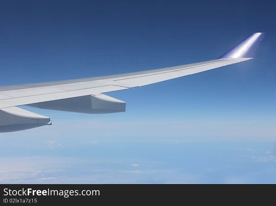 View of jet plane wing with cloud patterns