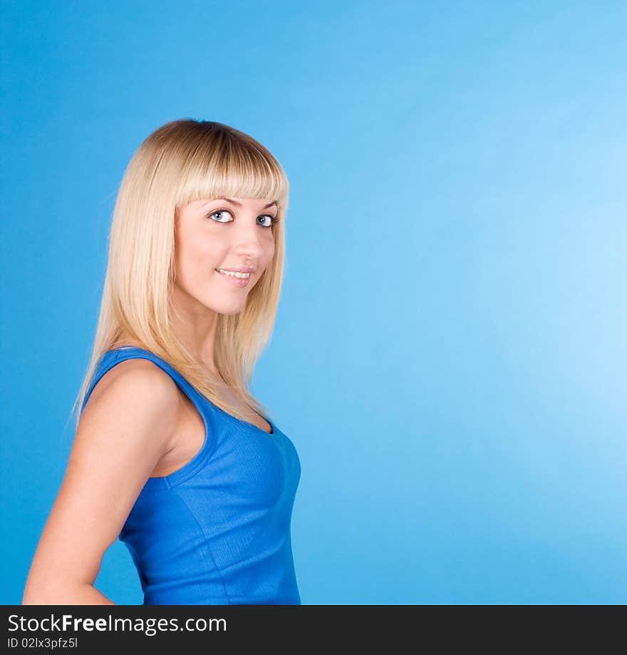 Portrait of a beautiful blonde on a blue background. Portrait of a beautiful blonde on a blue background