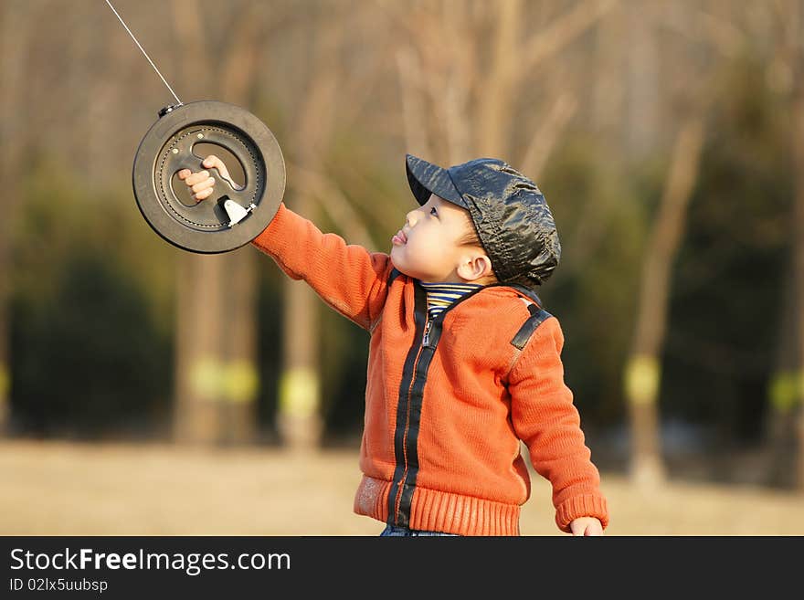 The little Asian boy playing kite with fun in winter