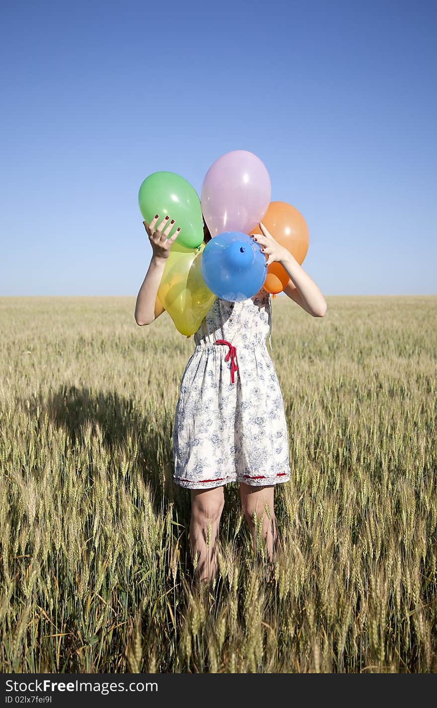 Girl with balloons at wheat field