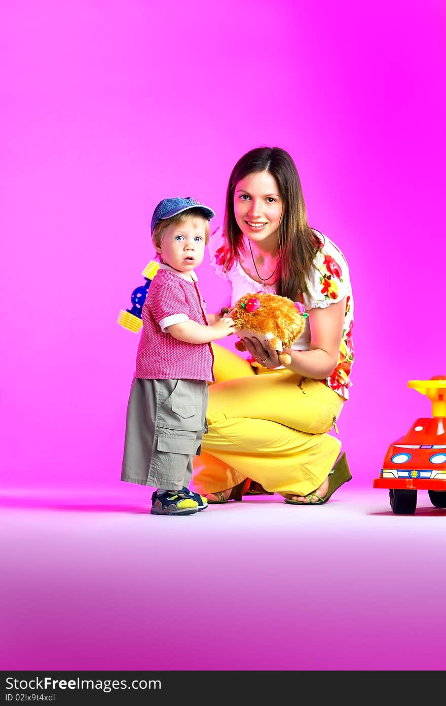 The portrait of a little boy and his mother playing with toys