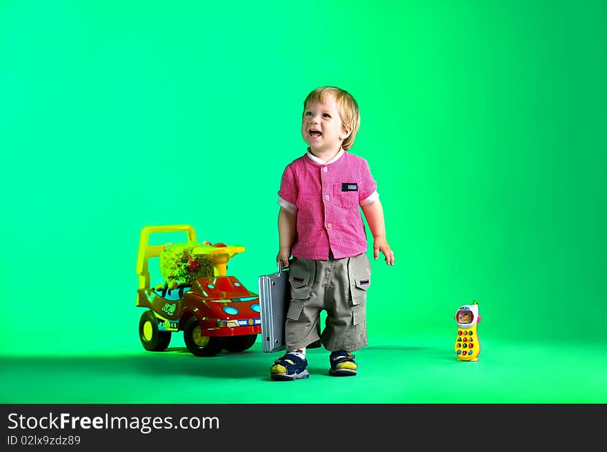 The portrait of a happy little boy carrying a toy notebook