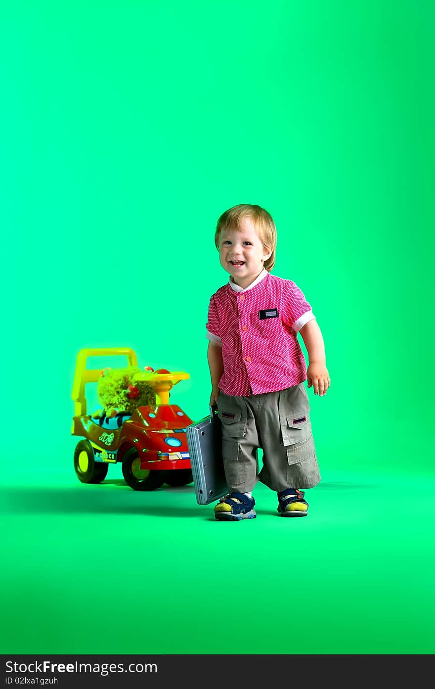 The portrait of a happy little boy carrying a toy notebook