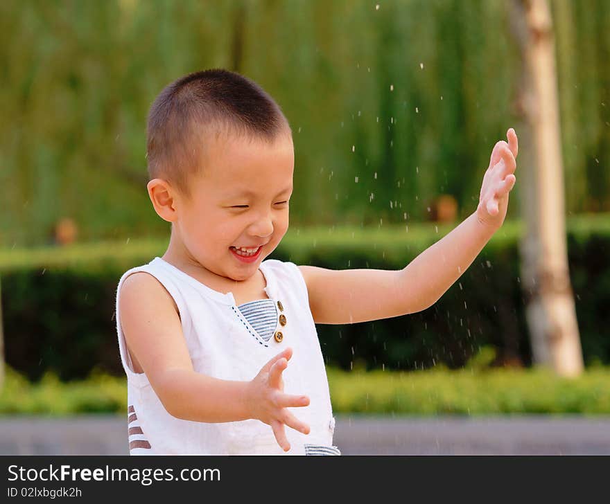 The little Asian boy playing sand with great fun in summer