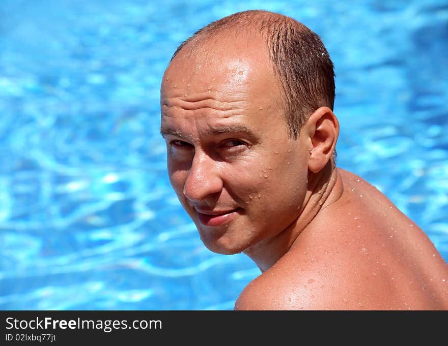 Portrait of a young man near the swimming pool, background