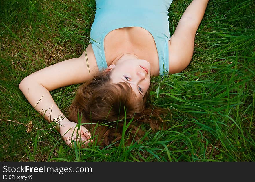 Portrait of a beautiful female lying on a grass, it is summer and she is relaxing. Portrait of a beautiful female lying on a grass, it is summer and she is relaxing