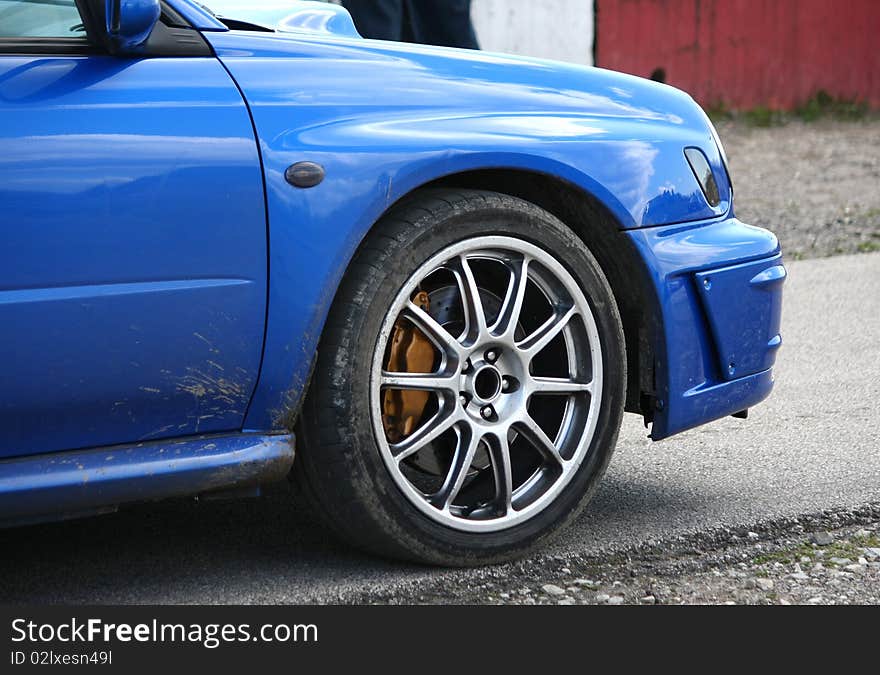 Blue sport car detail on a race track