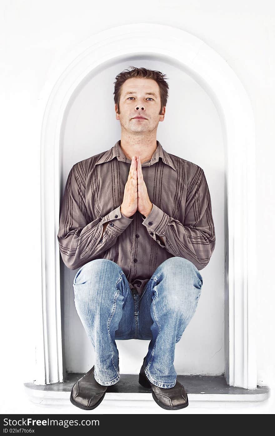 Man on a white background praying looking straight at the camera. Man on a white background praying looking straight at the camera