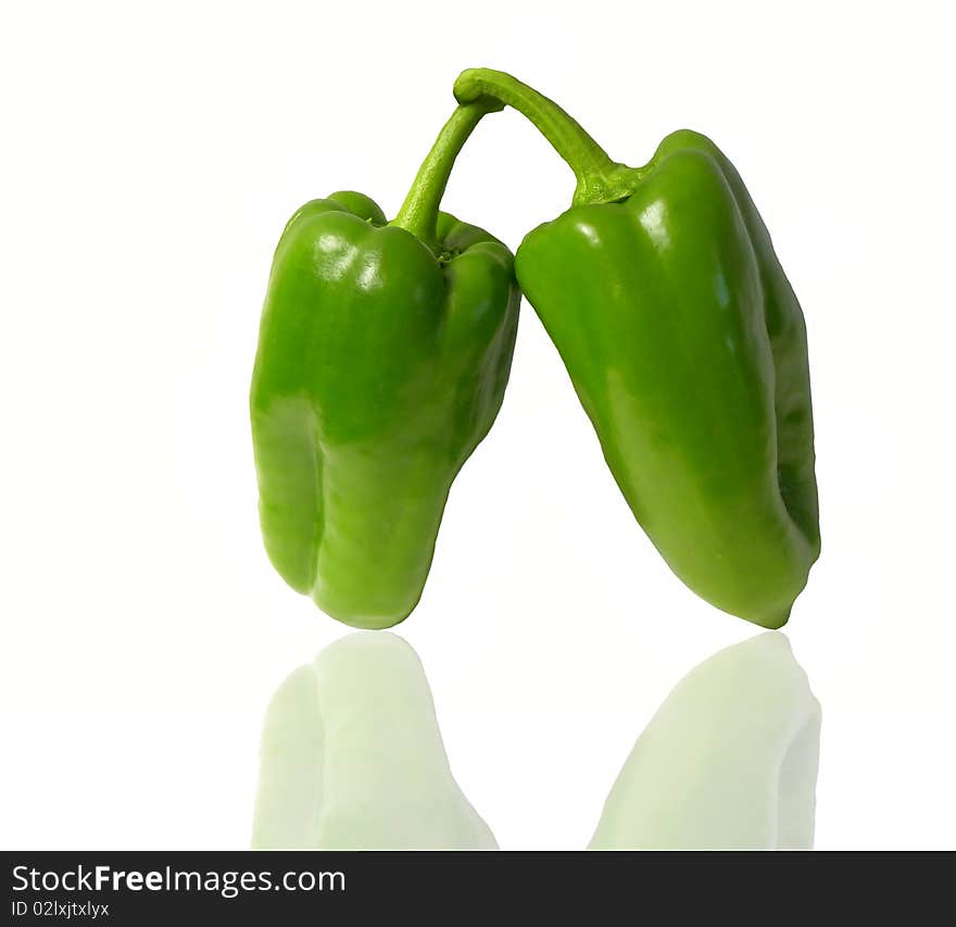 Two green peppers isolated on white background