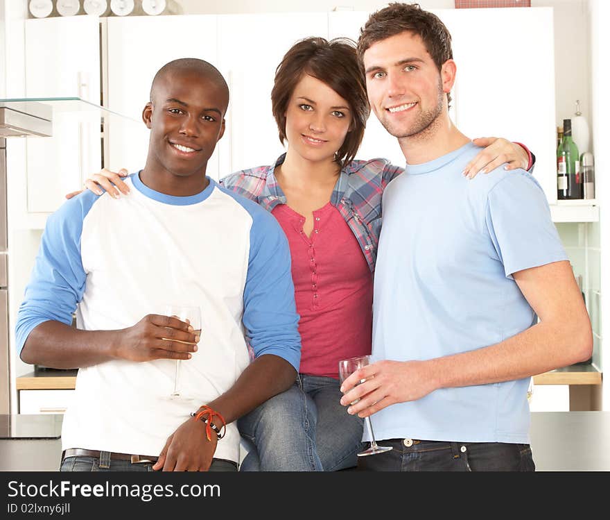 Young Friends Enjoying Glass Of Wine In Kitchen