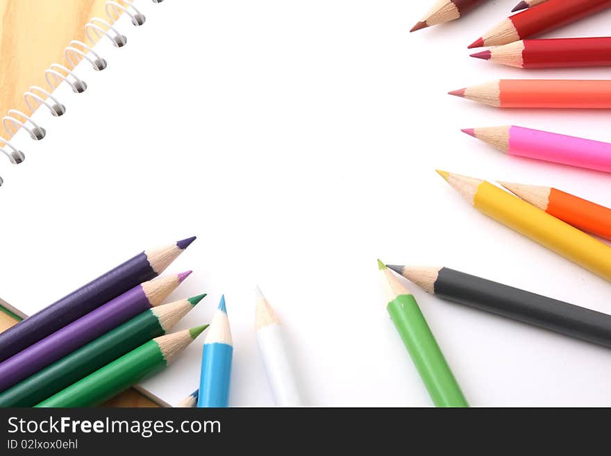 Wooden pencils of different colour on a white paper.