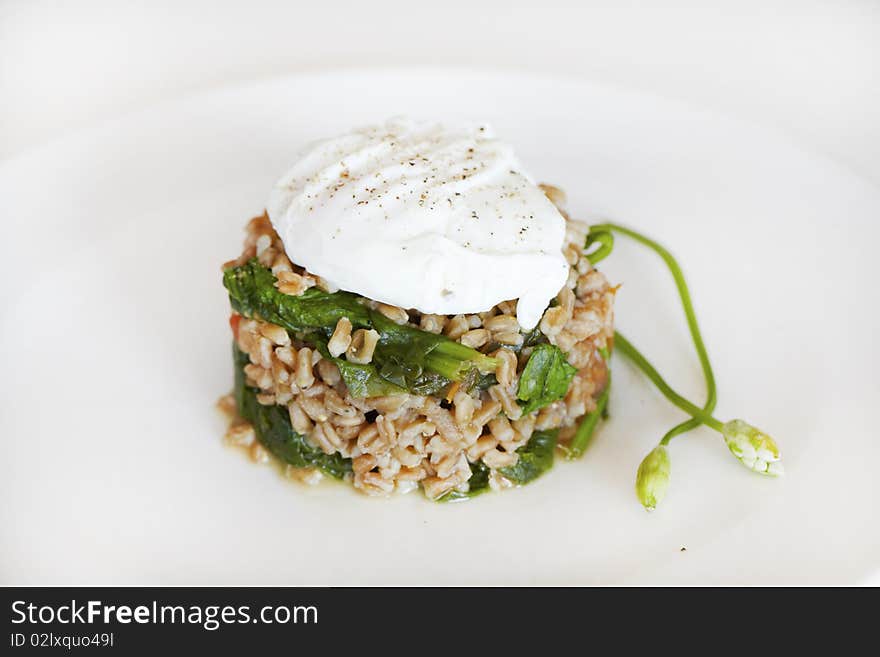 Poached egg on wheat grains with spinach