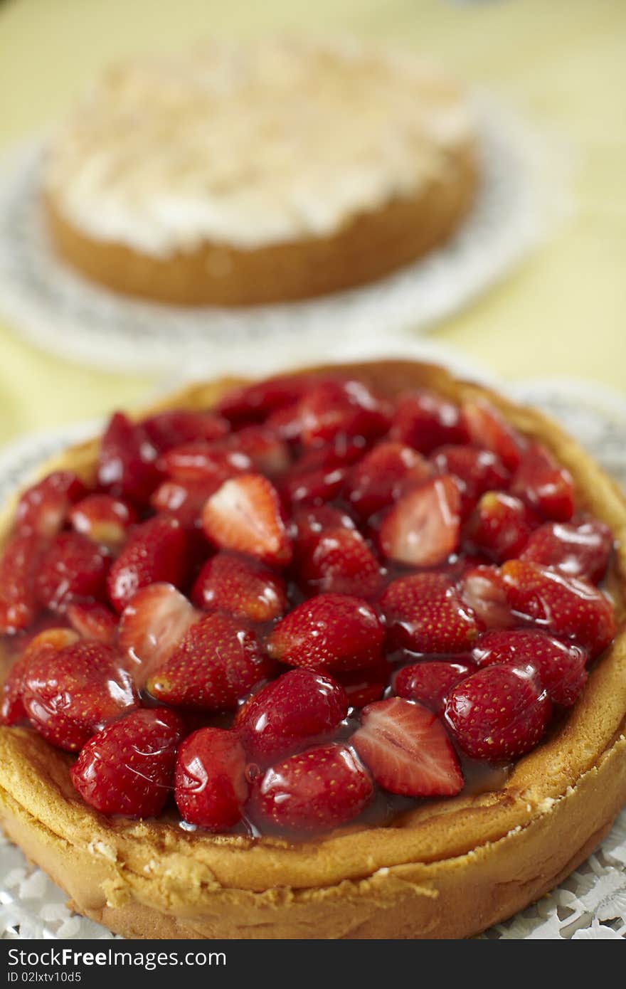 Strawberry cheesecake and fruit cake with meringue at the background.