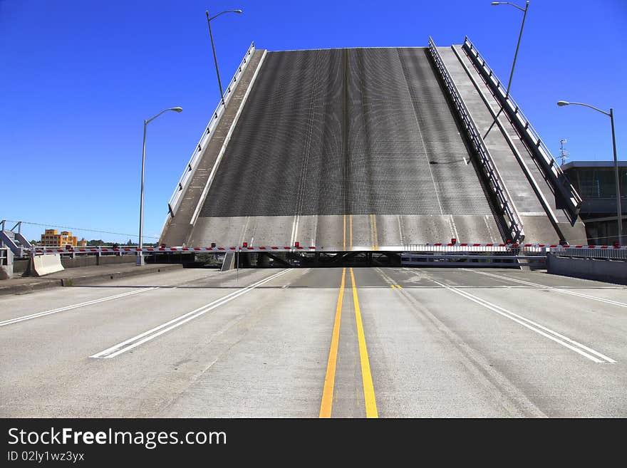 Bridge is raised for a passing push boat and its freight. Bridge is raised for a passing push boat and its freight.