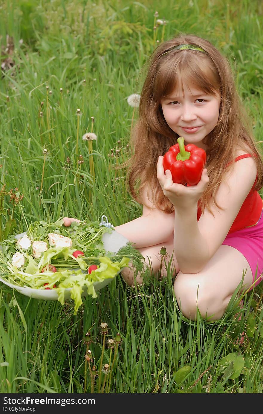 Portrait of the girl on a green grass with a dish of fresh vegetables. Portrait of the girl on a green grass with a dish of fresh vegetables