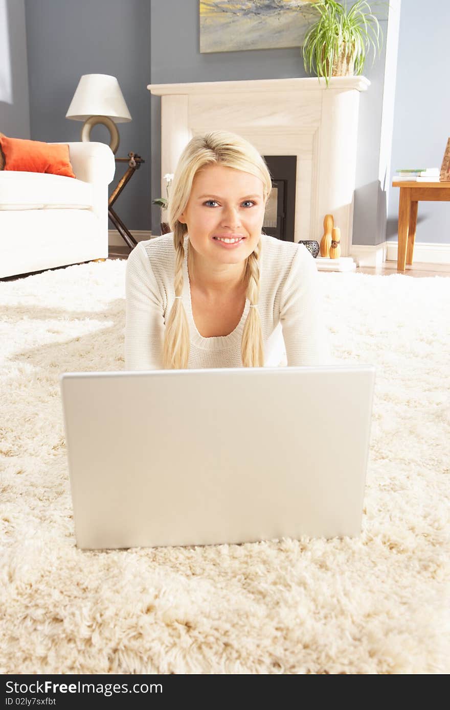 Woman Using Laptop Relaxing Laying On Rug At Home