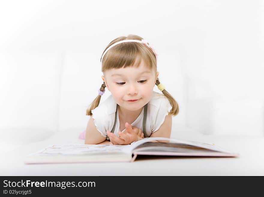 Sweet happy little girl reading book