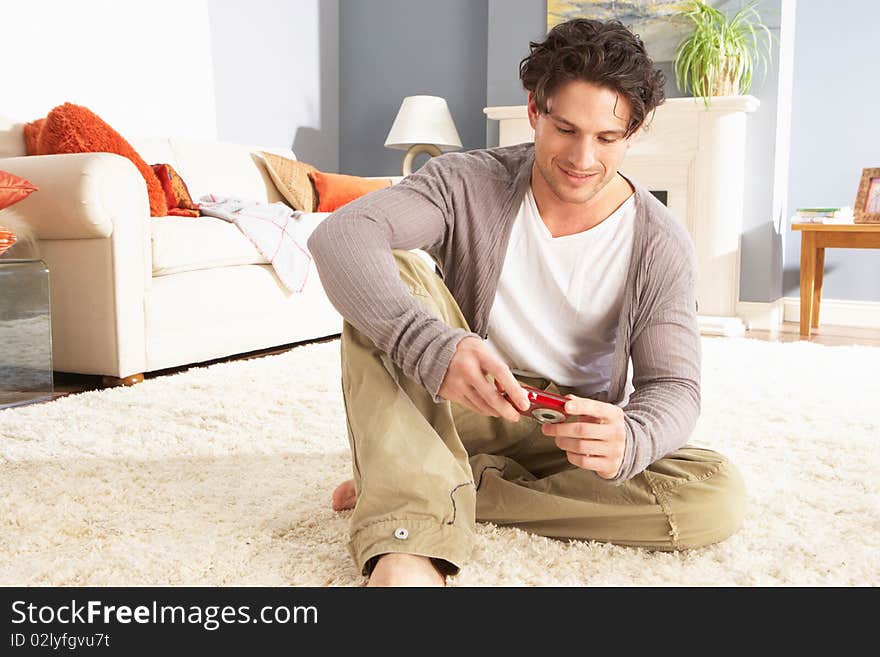 Young Man Looking At Photograph On Digital Camera