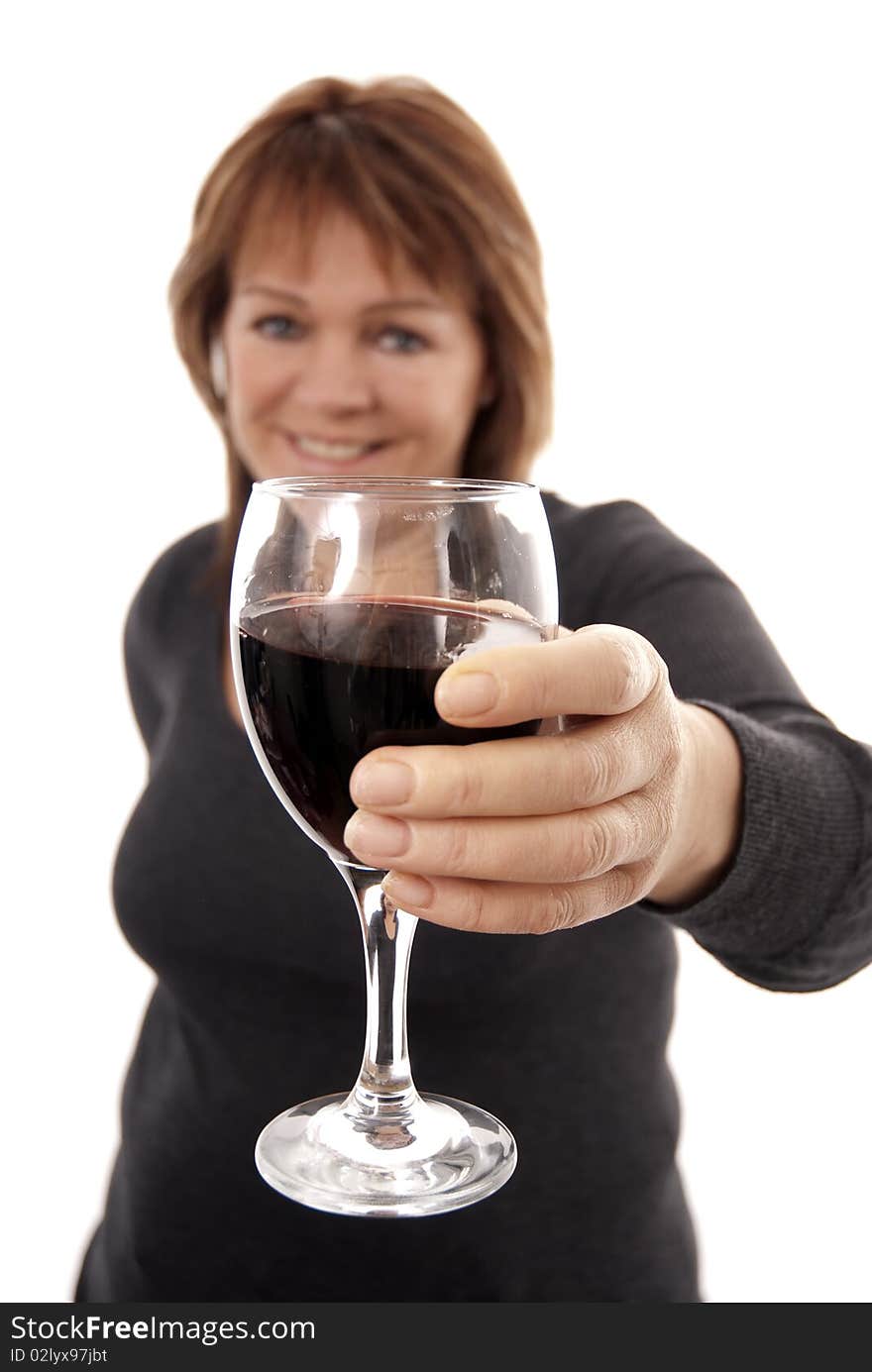 Woman holding glass of red wine to camera (focus on glass). Woman holding glass of red wine to camera (focus on glass)