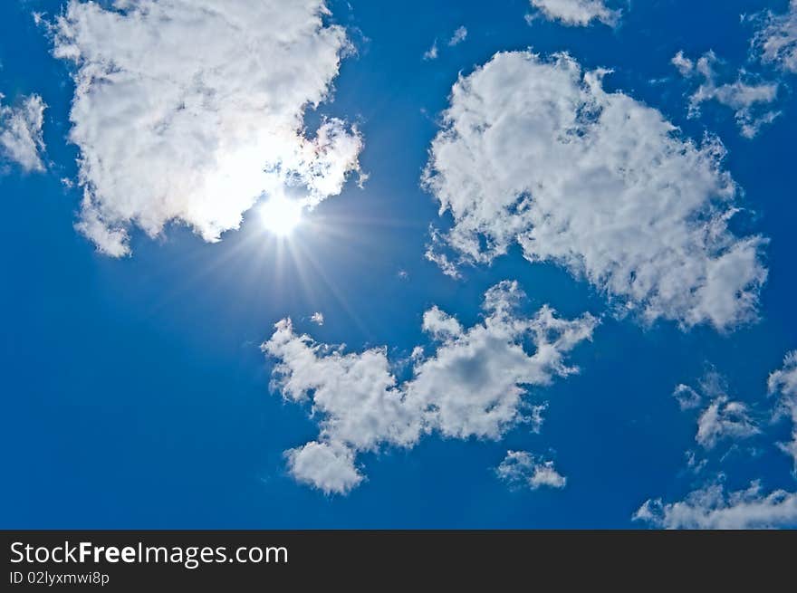 The sun sparkling behind clouds. The sun sparkling behind clouds