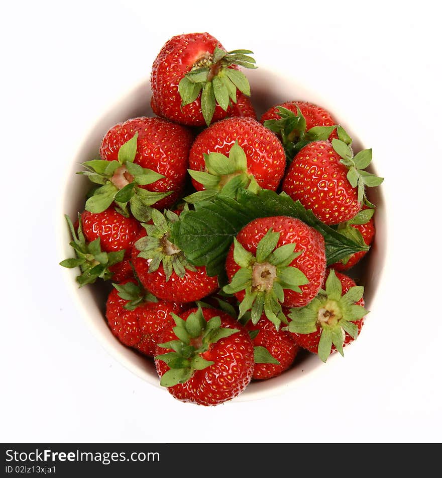 Strawberries in a bowl in close up on white background