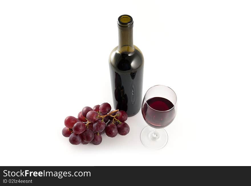 Wine bottle, red grapes and glass