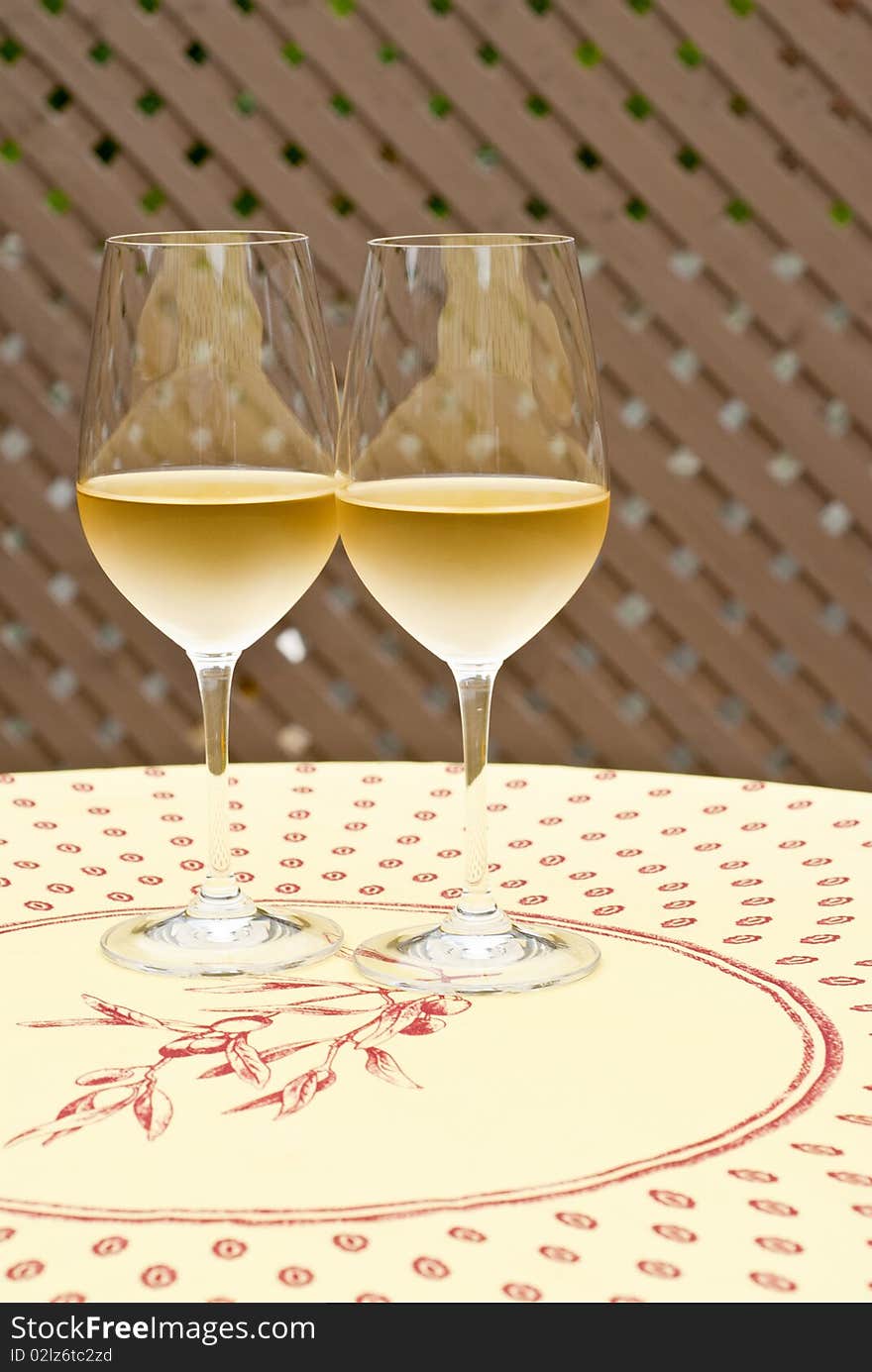 Two glasses of chilled white wine on a table. Two glasses of chilled white wine on a table.