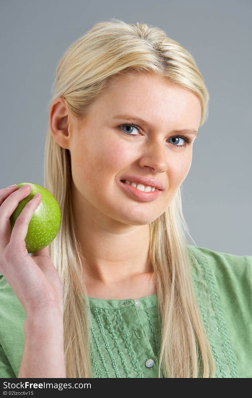 Woman Relaxing On Sofa Eating Apple At Home