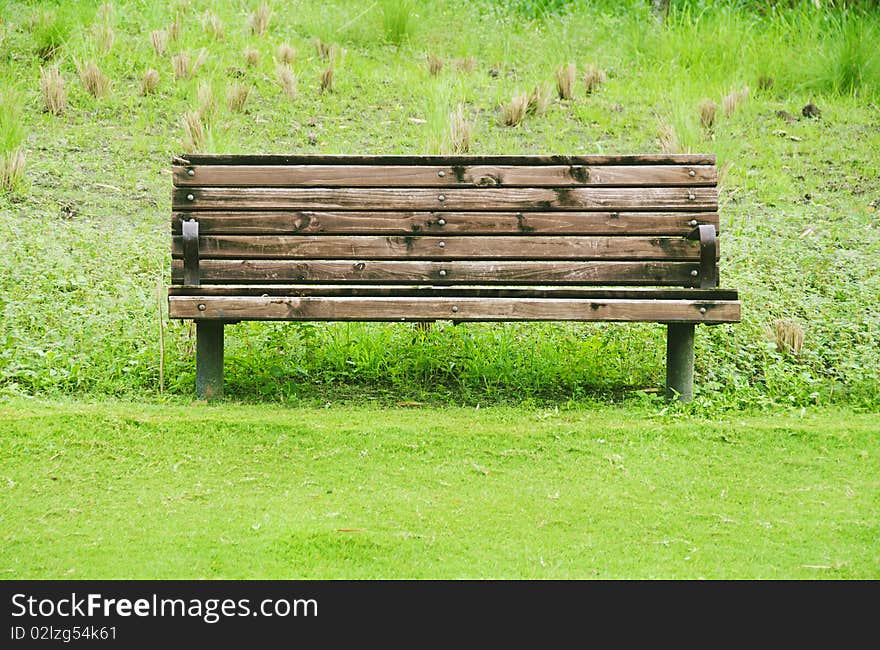 Wooden bench in a grassy area of golf course