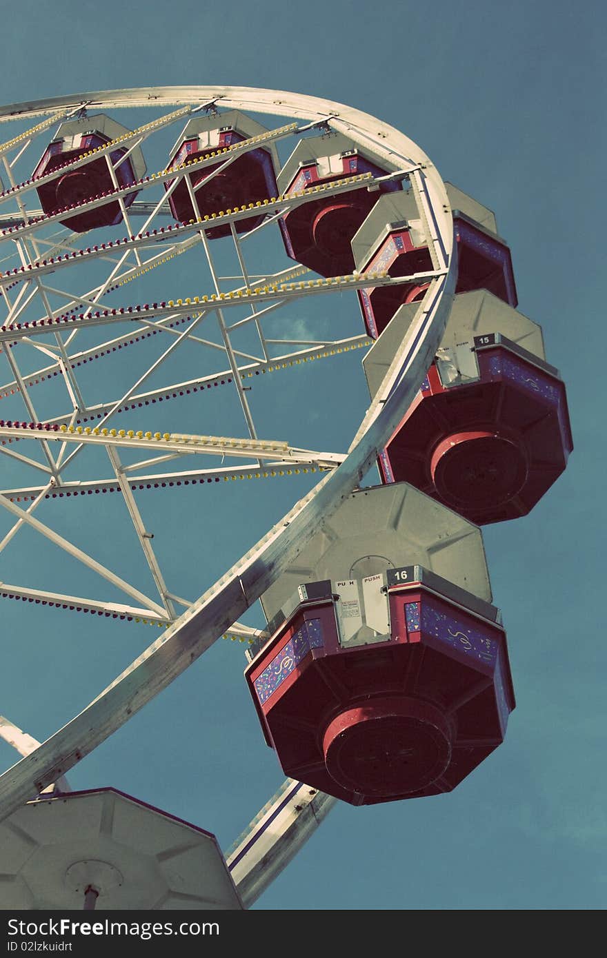 Looking up a ferris wheel with a blue sky background. Looking up a ferris wheel with a blue sky background