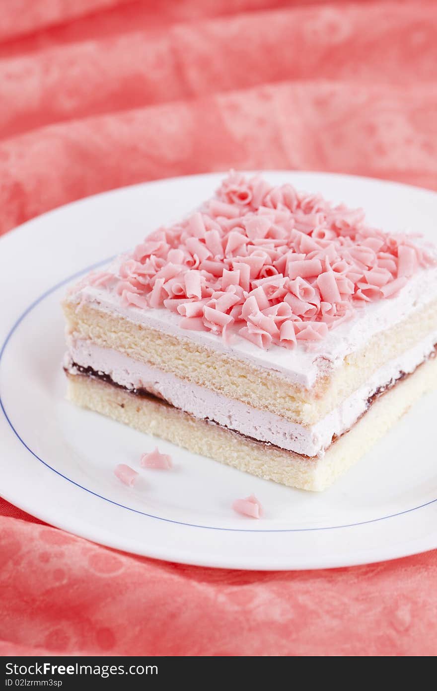 Close up of slice of fresh sweet cake on pink texture