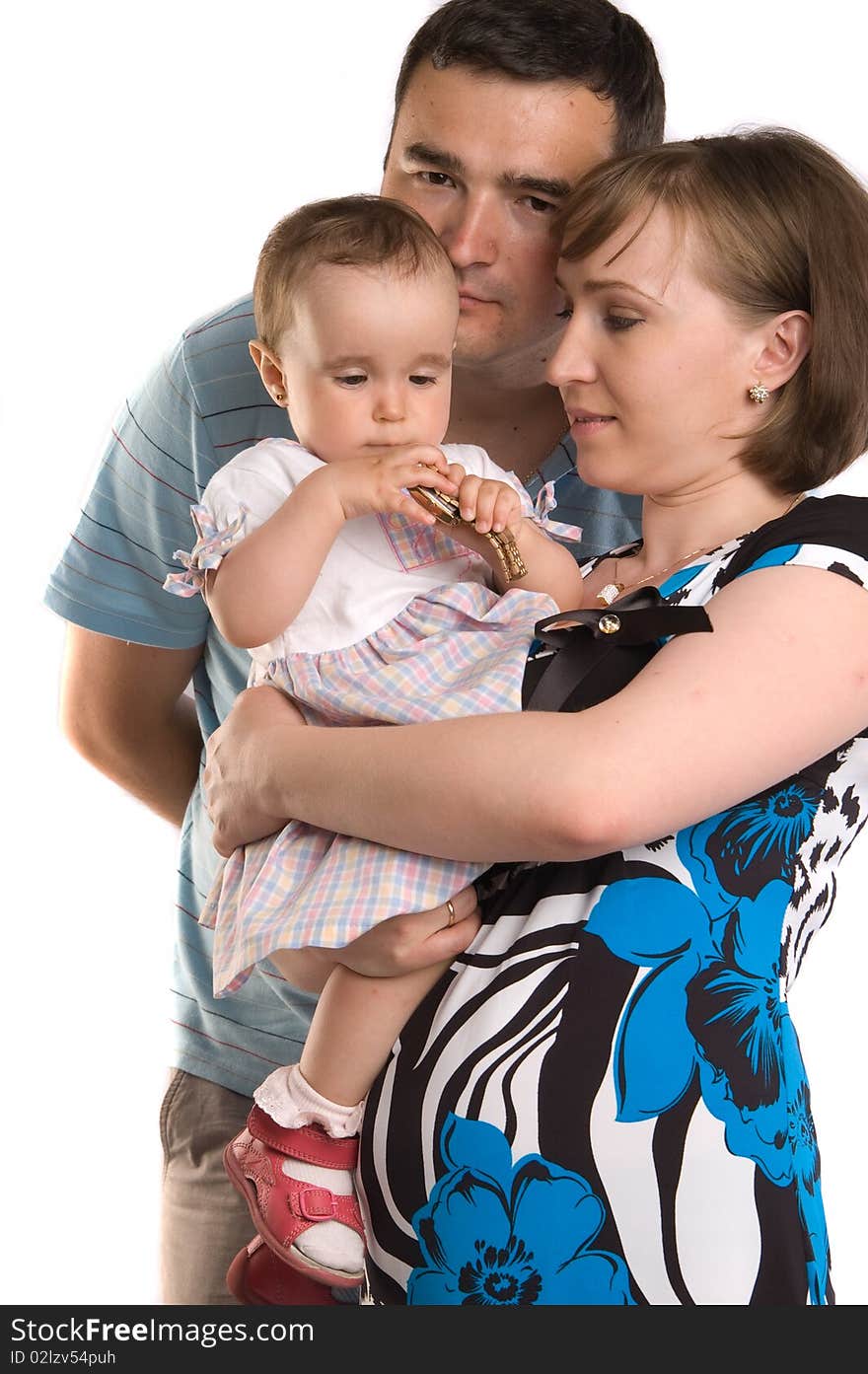 Happy family portrait of a baby with her parents over a gray background