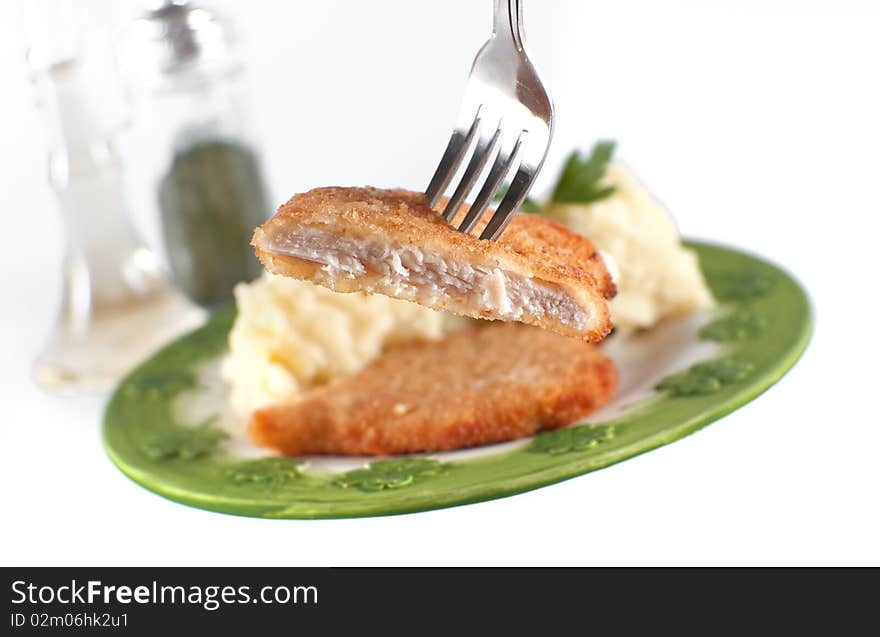 Chicken fillet, focus on fork and steak, isolated on white