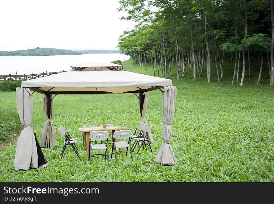 Desk in garden ,green plant and lake.