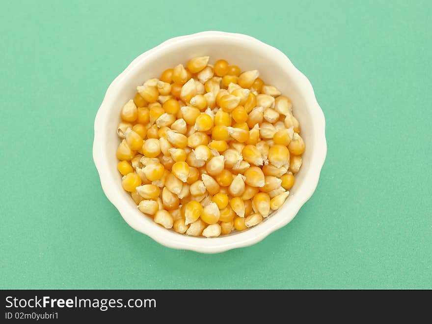 Yellow corn kernels macro photography close-green background